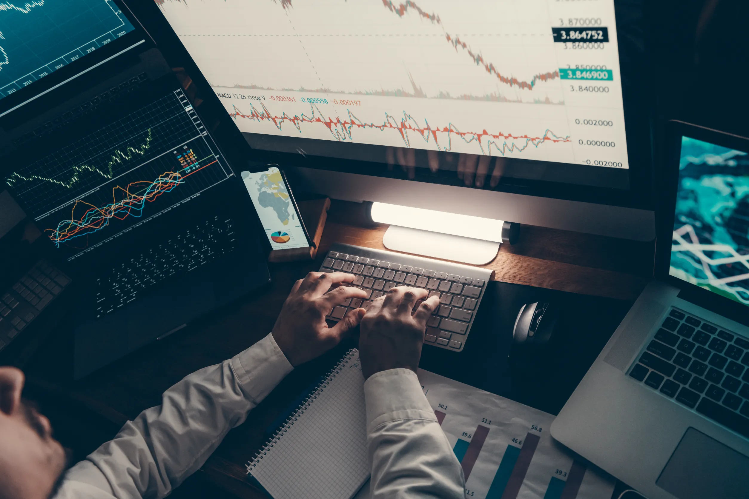 Close-up of financial broker working on computer while trading on stock market in night office