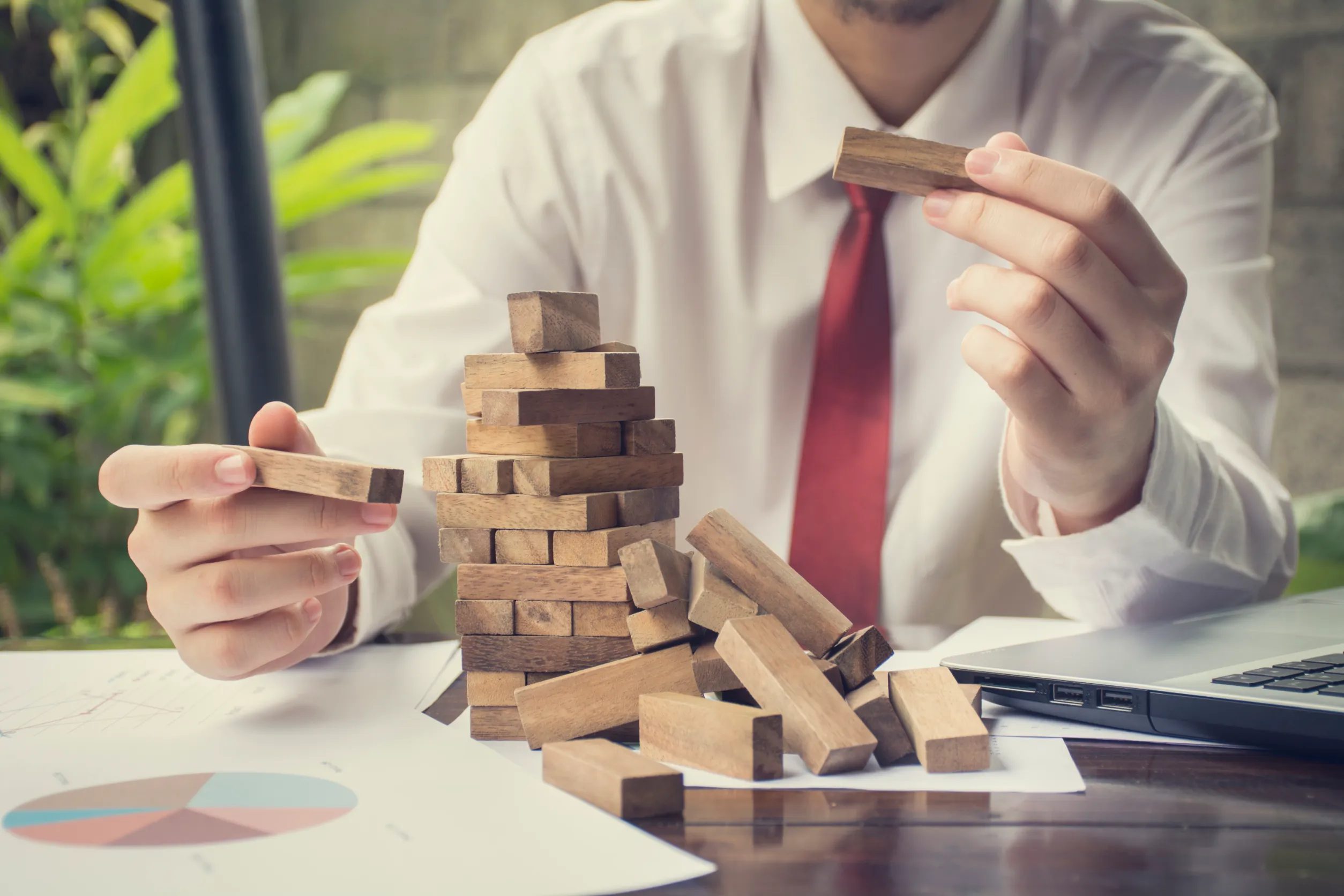 Concept of building success foundation. Businessmen hand put wooden blocks in the shape of a staircase<br />
